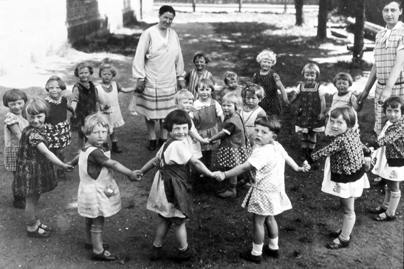 Kinderschule beim Ringelrose-Spiel um 1929 im Garten der Agathofschule. Die Kinder und zwei Erzieherinnen bilden zwei Kreise 