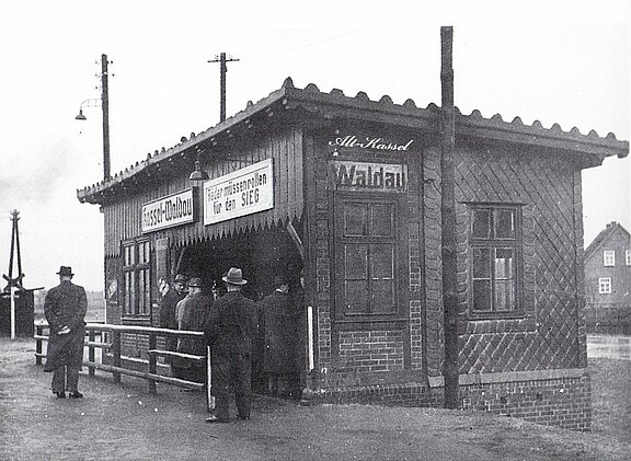 Personen am Bahnhof Waldau 1943, Schild mit Räder müssen rollen für den Sieg 