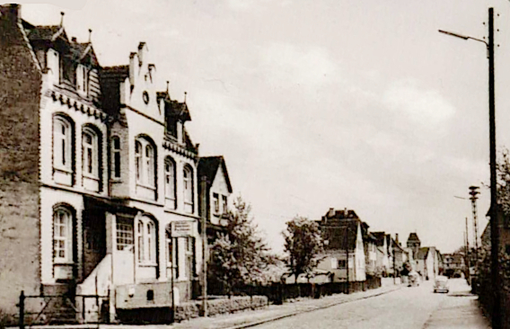 Blick in die Bergshäuser Straße im Vordergrund das Gasthaus zum Bahnhof, hinten im Ort erkennt man die Kirche 