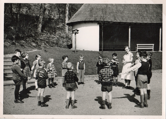 Kinder im Kreis mit Erzerzieherin 1955 